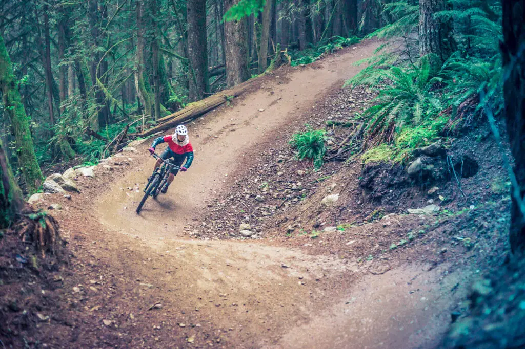 An adventurous mountain biker zooming down a trail in the Squamish woods.