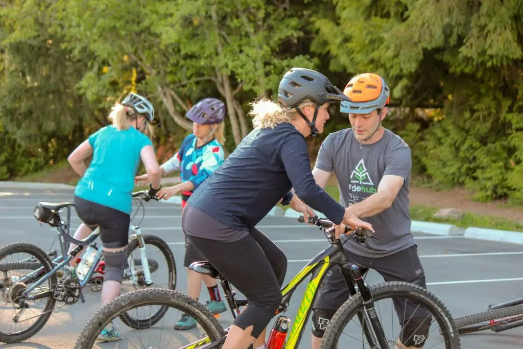Women's Courses 2 A group of people on an adventurous mountain biking expedition through a parking lot.